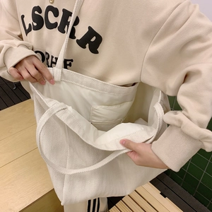 Detail view of large white canvas tote bag with spacious interior and zipper pocket