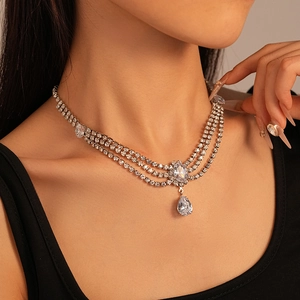 Gros plan sur un collier triple rang argenté avec cristaux ovales et poires