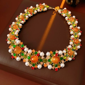 Détail du collier vintage avec pierres oranges, perles et cristaux colorés sur bronze