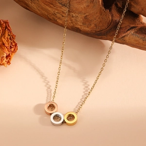 Vue détaillée du collier à trois anneaux imbriqués en or, argent et or rose poli