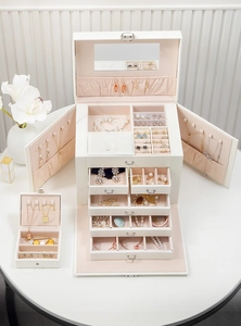 Detailed interior of a white jewelry box with pink velvet lining and vanity mirror