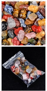 Close-up of hand-carved natural crystal frog figurines in assorted gemstones and packaging