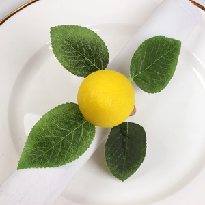 Handmade lemon napkin ring with green leaves on a white dinner plate for table setting