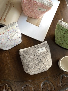 Set di quattro trousse in pile su tavolo di legno con riviste alla moda