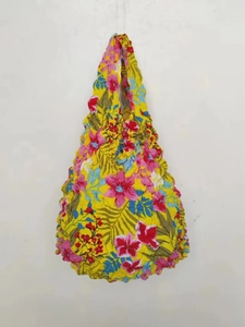 Detailed texture of the yellow floral shrinkable tote bag with pink and blue floral prints