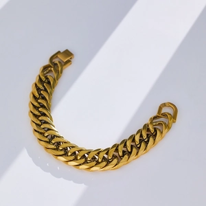Dettaglio del bracciale a maglia cubana dorato con finitura metallica lucida e chiusura