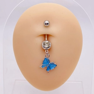 Detail of silver belly ring with blue butterfly pendant on a silicone navel model
