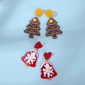Detail of acrylic Christmas earrings showing cartoon tree and red snowflake bell charms