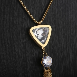 Macro detail of gold tassel pendant necklace with triangle zircon and crystal stones