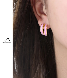 Detail of pink enamel and gold-plated stainless steel layered hoop earrings on model