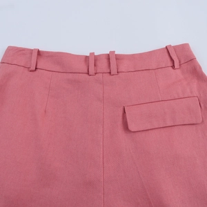 Close-up of pink trousers back waist with belt loops and a functional patch pocket