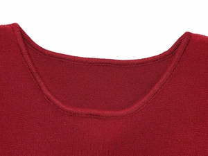 Détail rapproché du col d'une robe en tricot rouge montrant la texture et les coutures