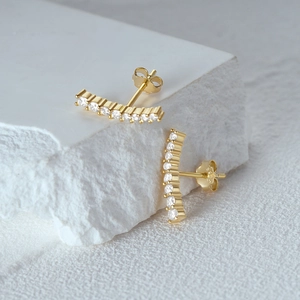 Detail showing S925 silver stamp on gold crescent pearl earrings with clear crystals