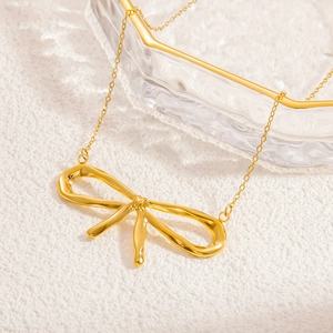 18k gold plated titanium steel butterfly necklace on soft white textured background