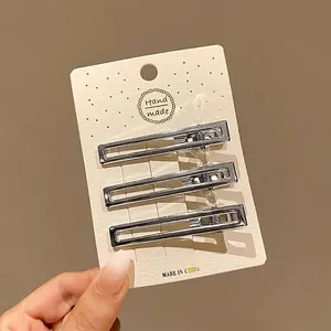 Vue rapprochée de trois pinces à cheveux y2k en métal argenté de 6 cm au design creux