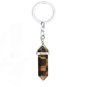 Macro detail of a hexagonal Tiger Eye crystal pillar keychain with a silver metal link chain