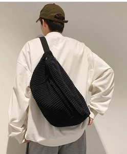 Close-up of black corduroy crossbody bag texture and large capacity fit on model