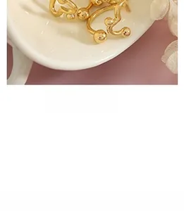 Detailed close-up of vintage gold-plated twisted earrings with cat-eye glass inlays