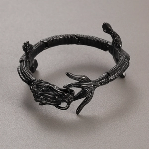 Macro detail of a flexible black dragon bracelet showing intricate joints and head carving