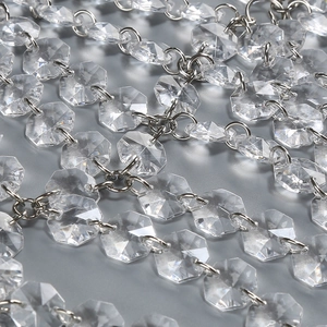 Macro detail of clear octagonal crystal bead chains with silver metal rings for decor
