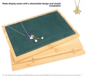 Detail of dark green velvet necklace display board with multiple slots and wood base