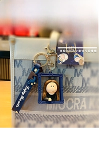 Detail of creative Mona Lisa PVC keychain with Enjoy the arts strap on a handbag