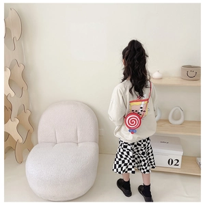 Rear view of a young girl wearing a bright red lollipop-shaped crossbody bag