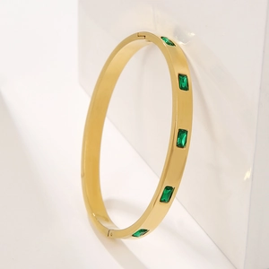 Vintage gold titanium steel cuff bracelet with emerald green zircon stones on white cubes