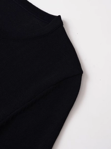 Detail of fine knit texture on a black crewneck sweater with ribbed collar finish