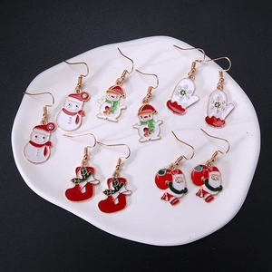Christmas alloy earrings set featuring snowman, Santa, and festive charms on a white tray