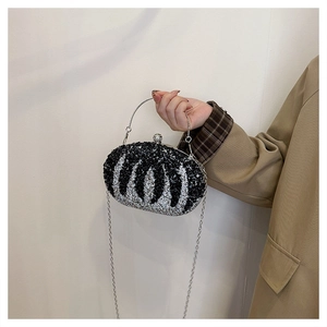 Detailed view of luxury evening clutch with black and white wavy rhinestones and metal handle