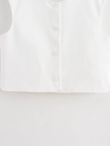 Close-up of white v-neck vest showing fine twill texture and four matching buttons