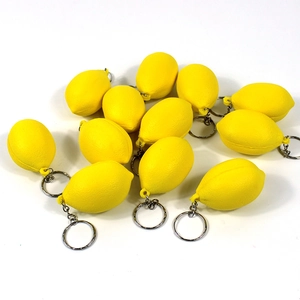 Close-up of realistic yellow lemon fruit keychains with textured surface and metal rings