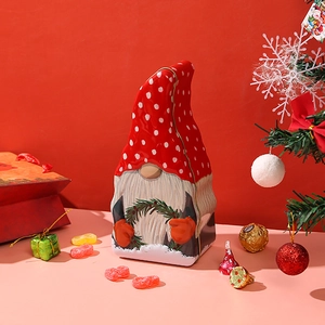 Christmas gnome tin box for candy and cookies with red festive holiday background