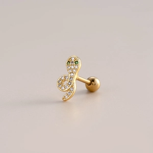 Macro detail of golden snake stud earring with green zircon eyes and clear crystals