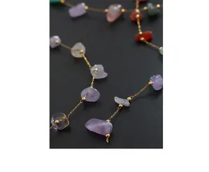 Macro detail of bohemian gold chain necklace with colorful irregular natural stones