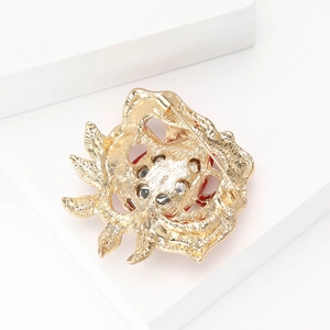Detail view of the secure pin clasp on the back of the golden enamel rose flower brooch