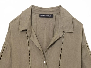 Dettaglio dello scollo della camicia in lino verde oliva con trama del tessuto