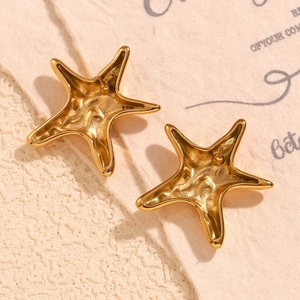 Macro view of gold starfish earrings focusing on the back posts and irregular texture