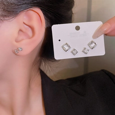 Detail of square zircon stud earrings with S925 silver hallmarks and quad-prong setting