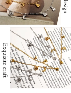 Detail of gold and silver paperclip chains with rose, moon, and butterfly charms