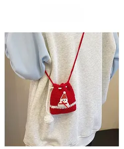 Close-up of a handmade red knitted snowman drawstring bag with cute pom-pom detail