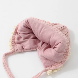 Pink knit baby bonnet with delicate lace trim and warm lining for winter infants