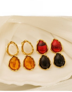 Detail view of teardrop titanium steel earrings in amber, red, black and white colors
