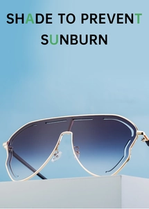 Close-up of golden metal frame sunglasses with gradient blue-grey lenses on a white stand