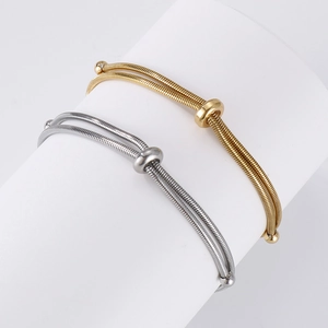 Detail of adjustable gold and silver snake chain bracelets with sliding metal beads