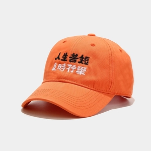 Close-up of orange cotton baseball cap with life quotes embroidery in fine detail