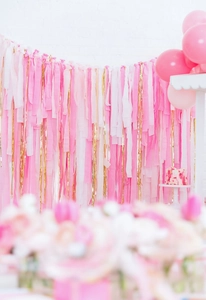 Pink and gold crepe paper streamers used for party backdrop and celebration decor