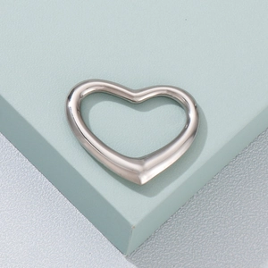 Macro shot of a polished silver heart-shaped hollow pendant with metallic luster