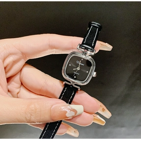 Detail of square black watch dial with rhinestone markers and black leather strap